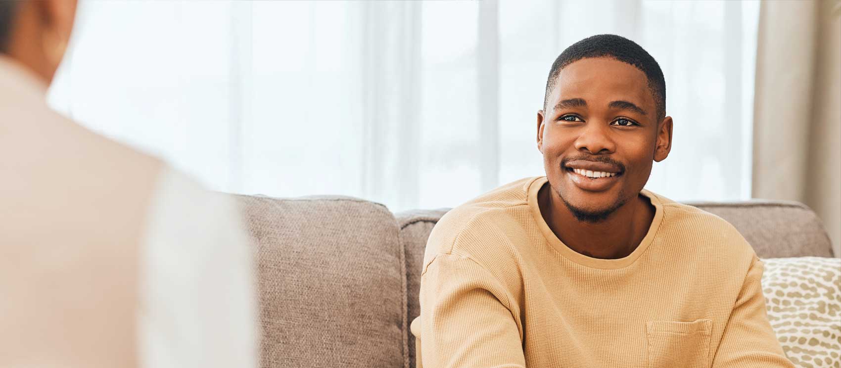 Young black man discussing Mental Health Insurance Coverage and smiling