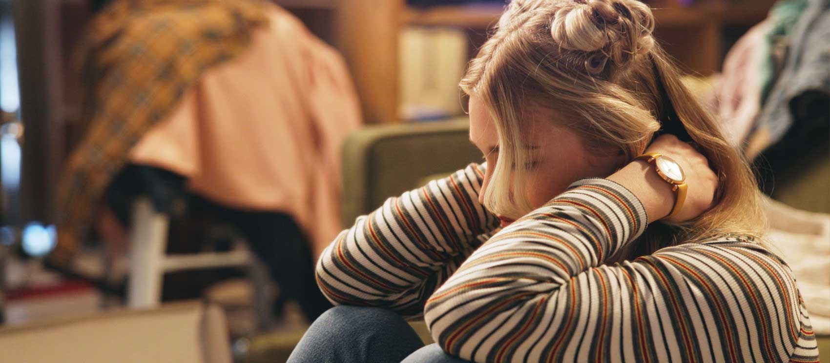 Young woman sitting looking down an d feeling sad